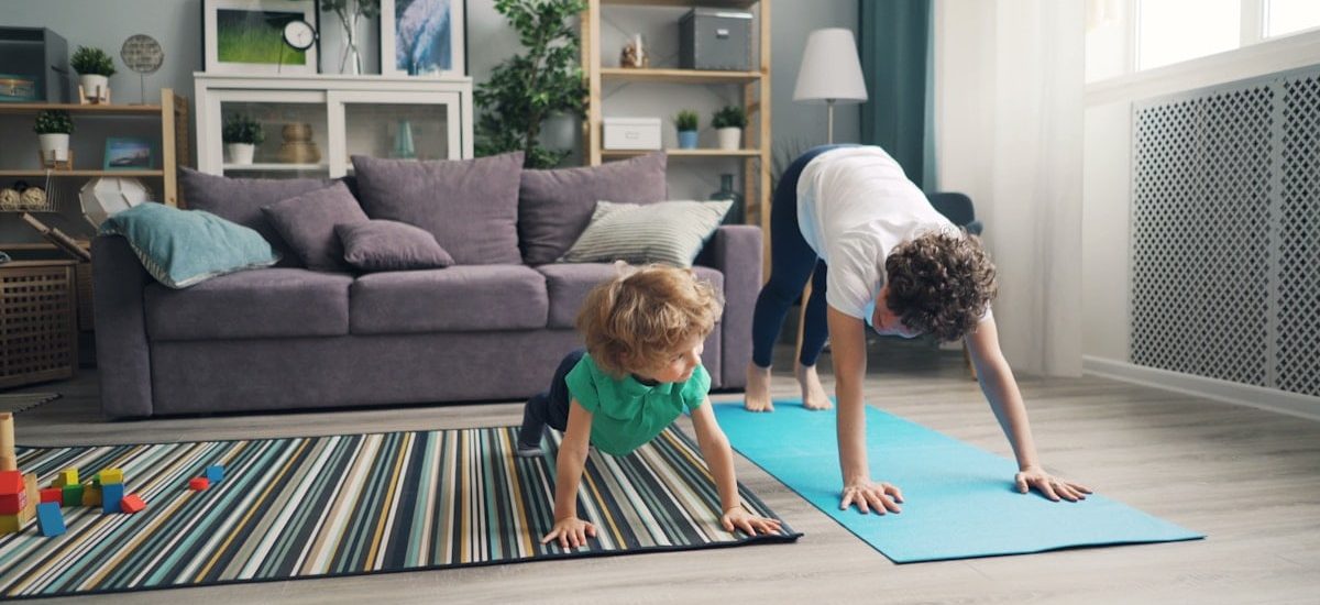 a woman and a child doing yoga in a living room