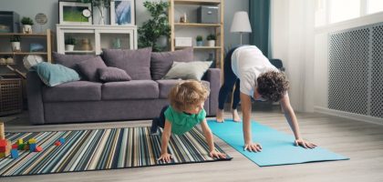 a woman and a child doing yoga in a living room