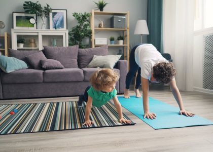 a woman and a child doing yoga in a living room