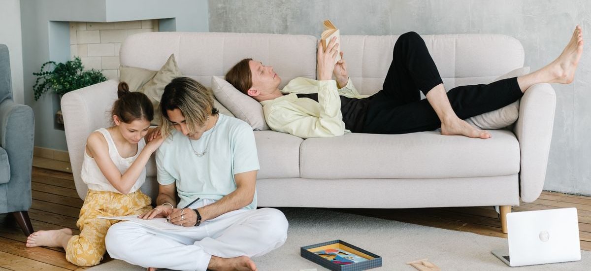 Father and daughter bonding in cozy living room with books and games, creating joyful family moments.